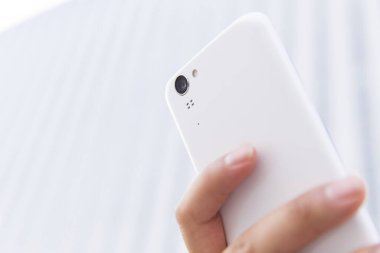 Bulanık arkaplanda beyaz akıllı telefon.