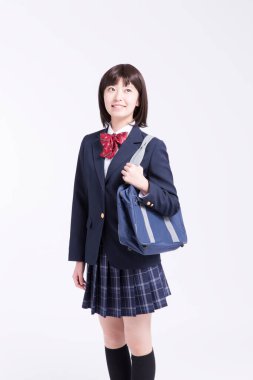 Çantalı gülümseyen Japon öğrencinin stüdyo portresi.