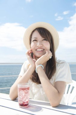 Deniz kenarındaki kafede oturan kadın.