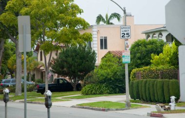 Park etmiş arabaların bulunduğu sessiz bir banliyö caddesi yeşil hız limiti tabelası