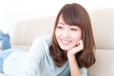 Kanepede yatan Asyalı kadın.