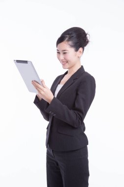 Dijital masa kullanan Asyalı genç iş kadınının stüdyo portresi