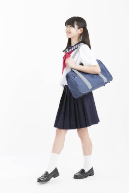 Beyaz arka planda okul üniformalı güzel genç bir öğrencinin portresi.