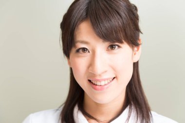 Hastanede gülümseyen Asyalı hemşire