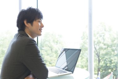 Dizüstü bilgisayarı olan genç bir adam.