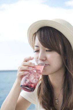 Sahilde limonata içen bir kadın. 