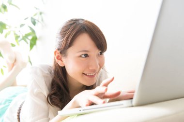 Dizüstü bilgisayar kullanan Asya genç kadın 