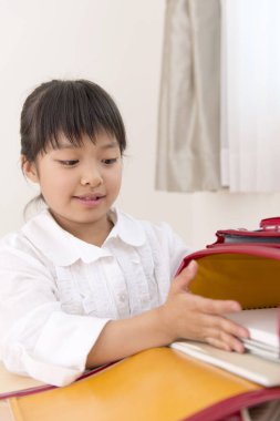 Küçük Asyalı kız ödevini yapıyor. 