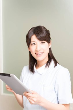 Tablet kullanan Asyalı kadın doktor