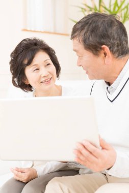 Dizüstü bilgisayar kullanan üst düzey Asyalı kadın ve erkek