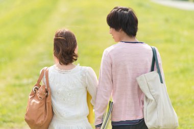 Bir çift mutlu genç Japon öğrenci doğada birlikte vakit geçiriyorlar.