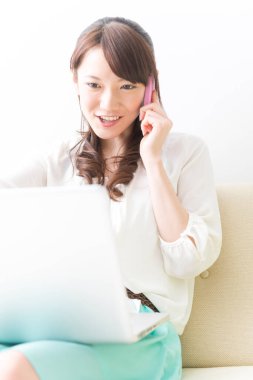 Bilgisayarı kullanırken Asyalı kadının telefonunu kapat.