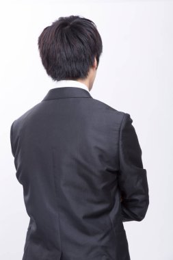 Takım elbiseli iş adamı. Arkadan bakıyor, iş adamının dikiz aynasından bakıyor.