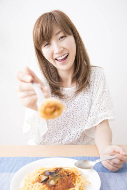 Evde spagettisi olan güzel bir Japon kadın.