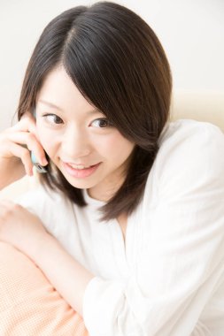 Beyaz üzerine izole edilmiş akıllı telefon kullanan güzel Asyalı bir kadının portresi.