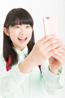 Beyaz arka planda izole edilmiş akıllı telefon kullanan genç Asyalı kız öğrenci 