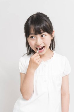 Diş ipi kullanan Asyalı bir kız. 