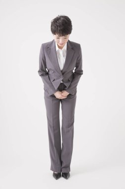 Takım elbiseli Asyalı kadın stüdyoda poz veriyor.