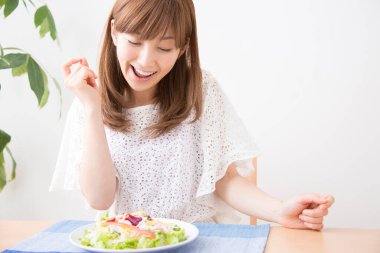 Gülümseyen Japon kadın taze salata tabağıyla