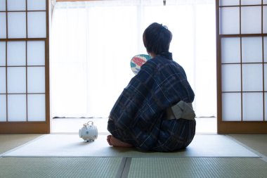 Etnik kaplıca otelinde geleneksel yukata giymiş yakışıklı Japon gencin portresi.