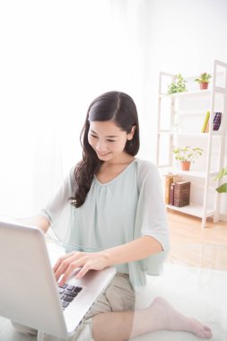 Bilgisayar kullanan Asyalı genç kadın. 