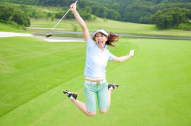 Golf sahasına atlayan Asyalı kadın. 