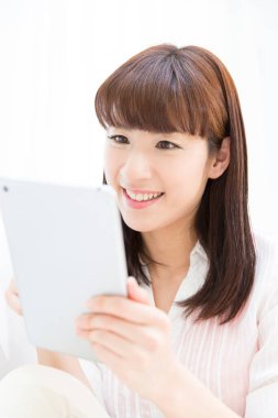 Elinde tablet tutan genç bir kadın.