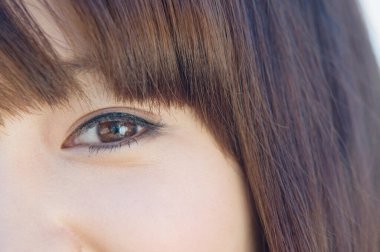 Uzun düz saçlı genç bir kadının güzel gözleri.