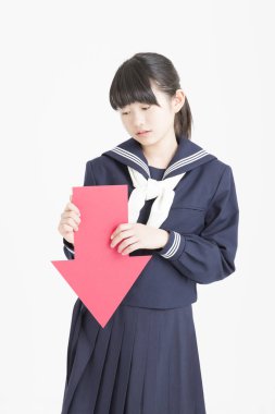 Okul üniformalı Asyalı bir kızın elinde ok tutan portresi.