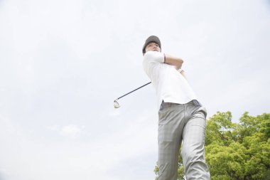 Golf oyuncusu sopayla topa vuruyor 