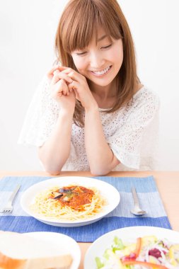 Evde spagettisi olan güzel bir Japon kadın.