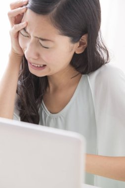 Bilgisayar kullanan Asyalı genç kadın hayal kırıklığına uğradı 