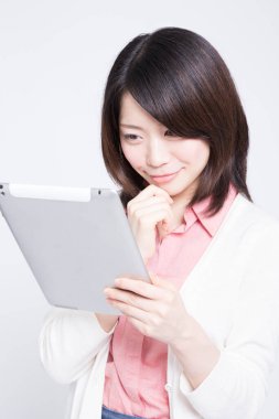 Beyaz arka planda tableti olan genç Asyalı kadın. 