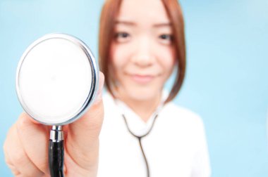 Steteskoplu genç ve güzel hemşirenin stüdyo portresi.