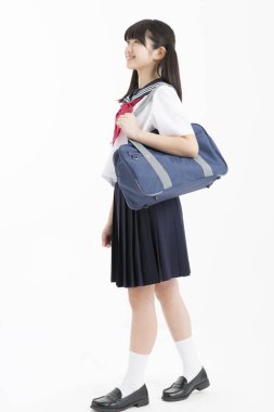 Beyaz arka planda okul üniformalı güzel genç bir öğrencinin portresi.