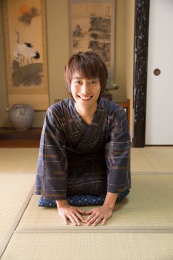 Etnik kaplıca otelinde geleneksel yukata giymiş yakışıklı Japon gencin portresi.