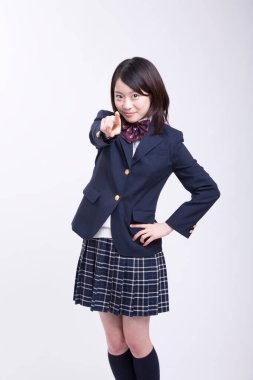 Üniformalı gülümseyen Japon öğrencinin stüdyo portresi.