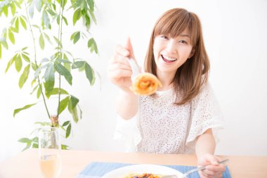 Evde spagettisi olan güzel bir Japon kadın.