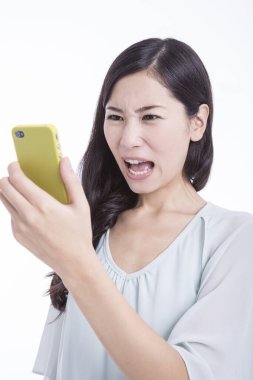 Genç kızgın kadın telefona bakıyor.