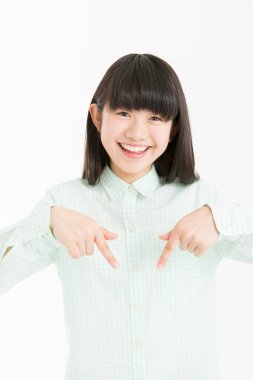 Genç Asyalı kız bir şey gösteriyor, beyaz arka planda izole edilmiş bir yeri işaret ediyor. 