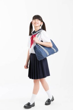 Beyaz arka planda okul üniformalı güzel genç bir öğrencinin portresi.