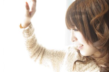 Genç Asyalı kadın pencereye bakıyor. 