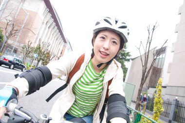 Şehirde bisiklet süren Asyalı kadın