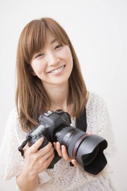 Kamerayı tutan Asyalı kadın fotoğrafçı