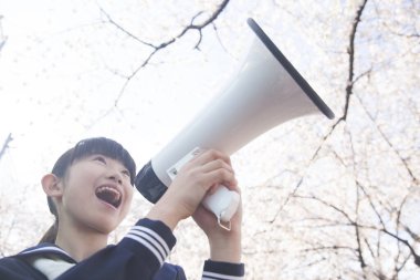 Sokaktaki hoparlörlü güzel Japon öğrencinin portresi.