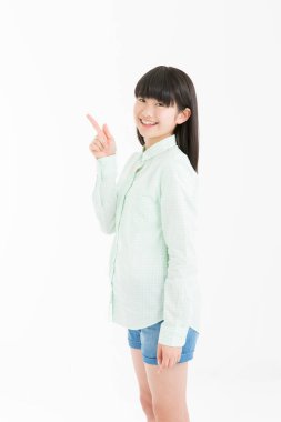 Genç Asyalı kız öğrenci beyaz arka planda izole edilmiş bir şey gösteriyor. 