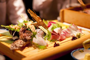 Tahta tabakta duran çeşitli saşimi parçaları.