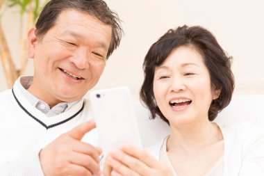 Cep telefonu kullanan mutlu yaşlı çift