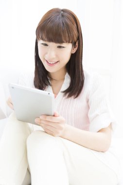 Tablet bilgisayar kullanan genç bir kadın
