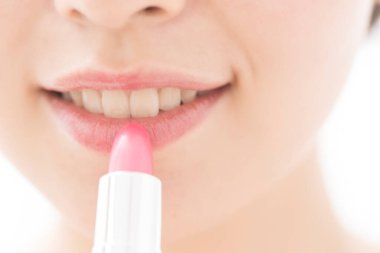 Güzel Asyalı genç kadın kırmızı ruj sürüyor.